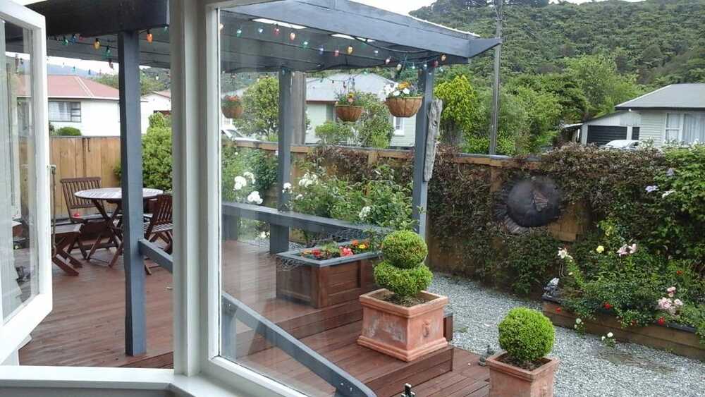 Covered deck with garden and outdoor seating at the bed and breakfast in Greymouth